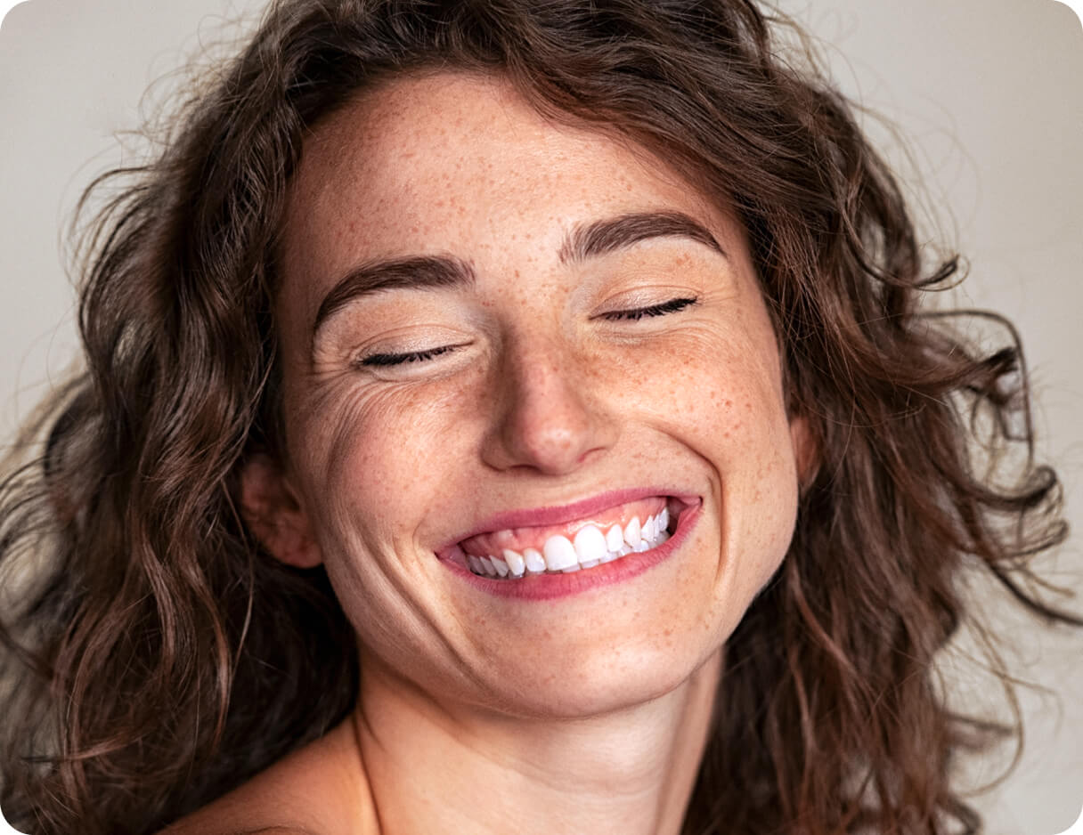 Woman laughing with her eyes closed